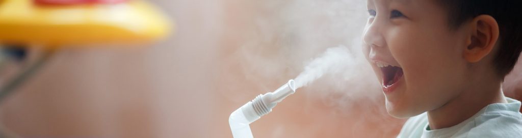 Little boy inhales from nebulizer
