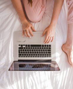 Women on bed using computer