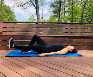 Woman performing heal slide on exercise mat