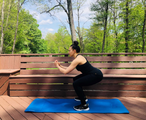 Woman performing squat on exercise mat