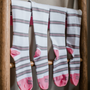 Motif medical compression socks hanging on wooden structure