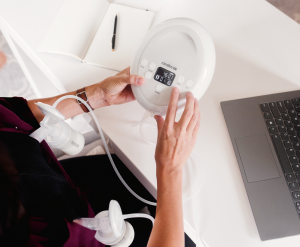 Woman using Cimilre breast pump while working