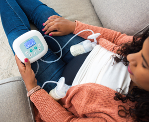 Mom pumping on couch with Cimilre S5+ breast pump