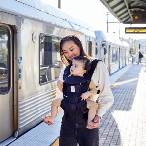 mom wearing Ergobaby Omni Breeze carrier holding baby