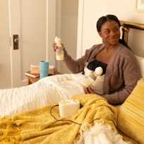 mom using electric breast pump provided through insurance 